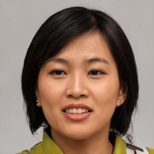 Joyful asian young-adult female with medium  black hair and brown eyes