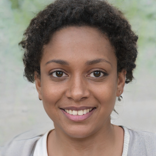 Joyful black young-adult female with short  brown hair and brown eyes