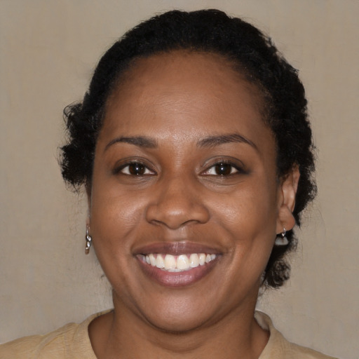 Joyful black young-adult female with short  brown hair and brown eyes