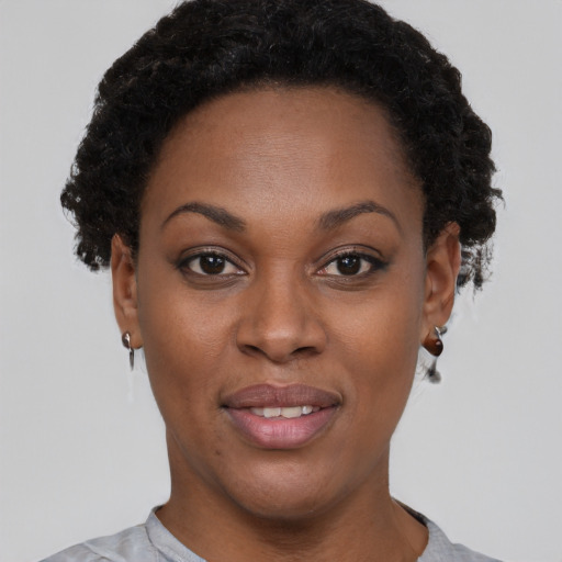 Joyful black young-adult female with short  brown hair and brown eyes