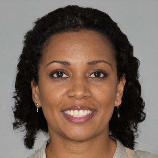Joyful black adult female with medium  brown hair and brown eyes