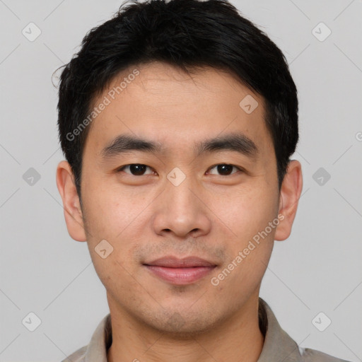 Joyful asian young-adult male with short  black hair and brown eyes