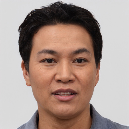 Joyful asian adult male with short  black hair and brown eyes