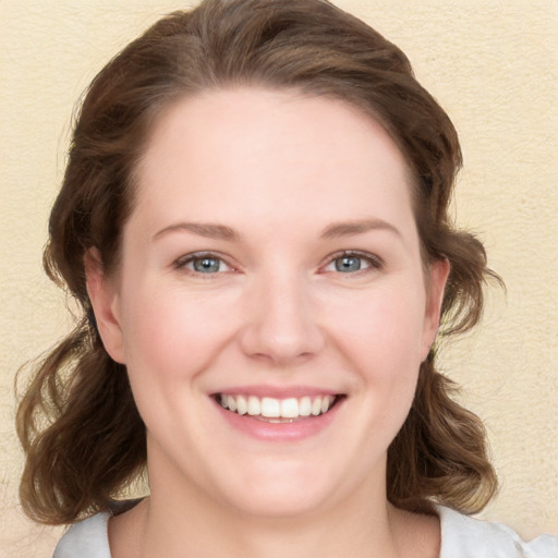 Joyful white young-adult female with medium  brown hair and blue eyes