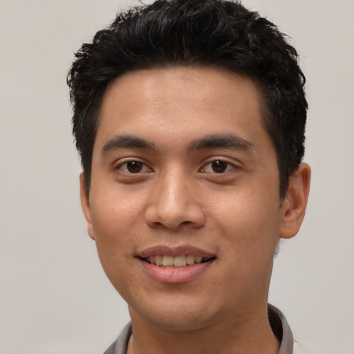 Joyful latino young-adult male with short  black hair and brown eyes