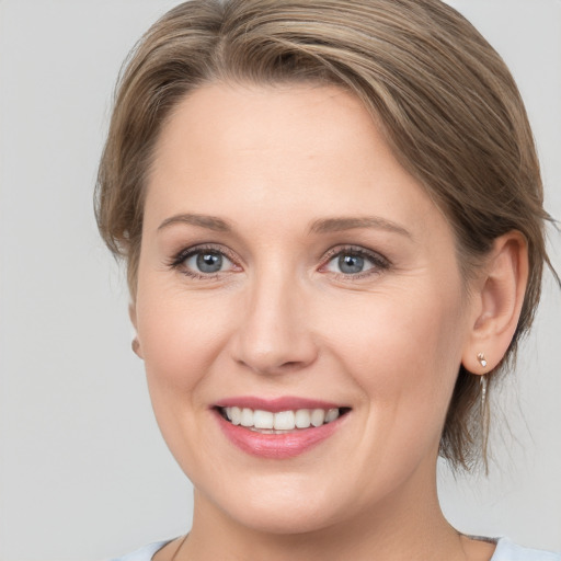 Joyful white young-adult female with medium  brown hair and blue eyes