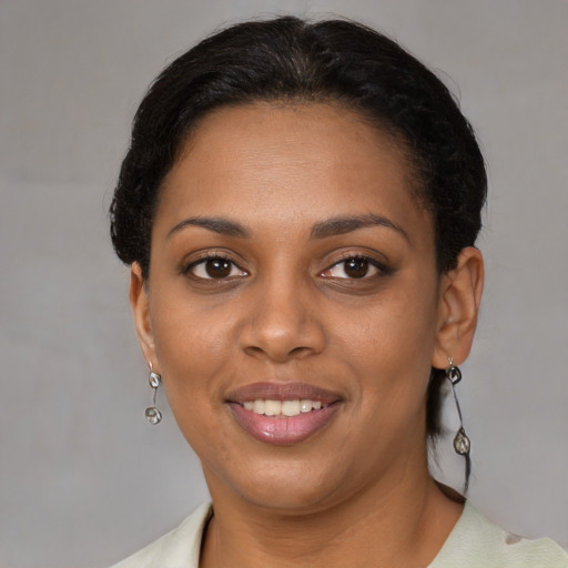 Joyful black young-adult female with short  brown hair and brown eyes