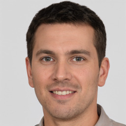 Joyful white young-adult male with short  brown hair and brown eyes