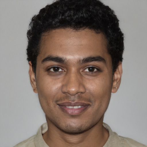 Joyful black young-adult male with short  black hair and brown eyes