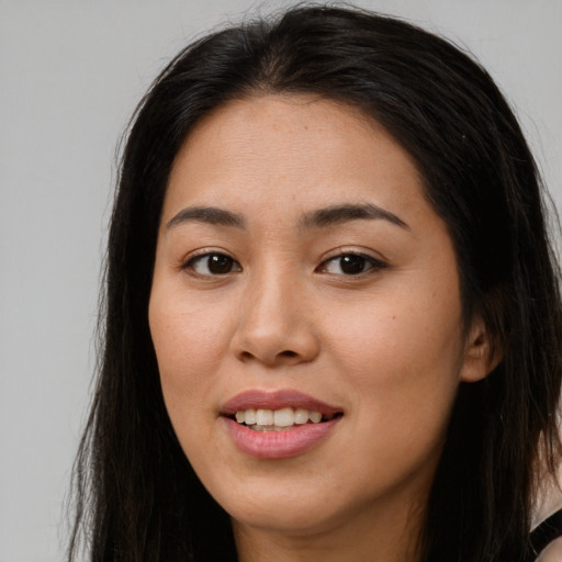 Joyful asian young-adult female with long  brown hair and brown eyes