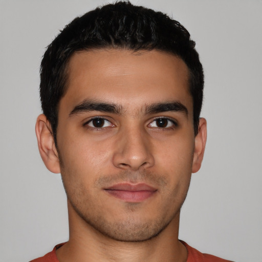 Joyful latino young-adult male with short  brown hair and brown eyes