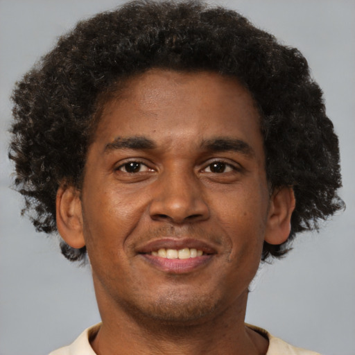 Joyful black young-adult male with short  brown hair and brown eyes
