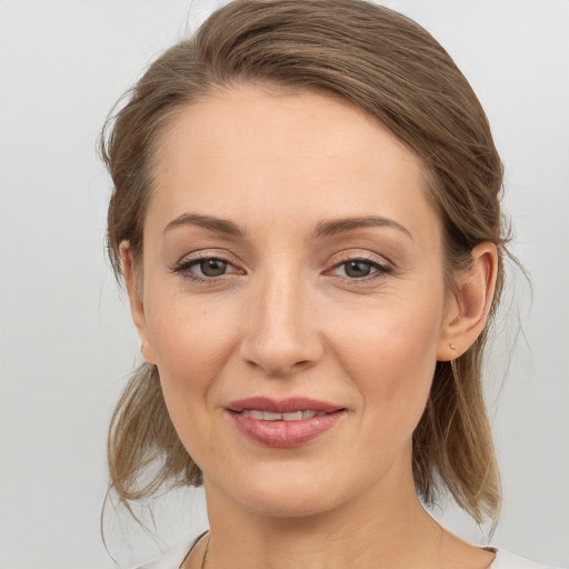 Joyful white young-adult female with medium  brown hair and grey eyes