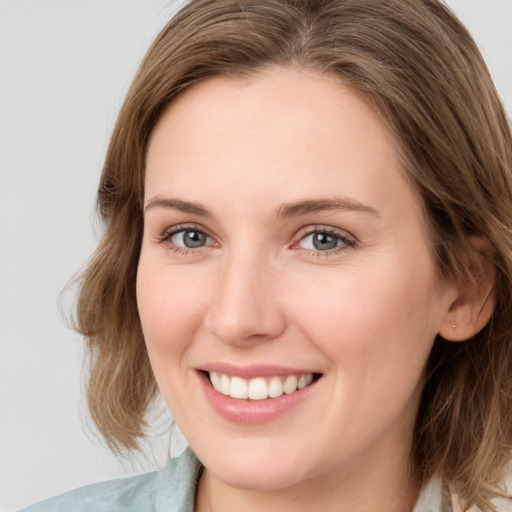 Joyful white young-adult female with medium  brown hair and blue eyes