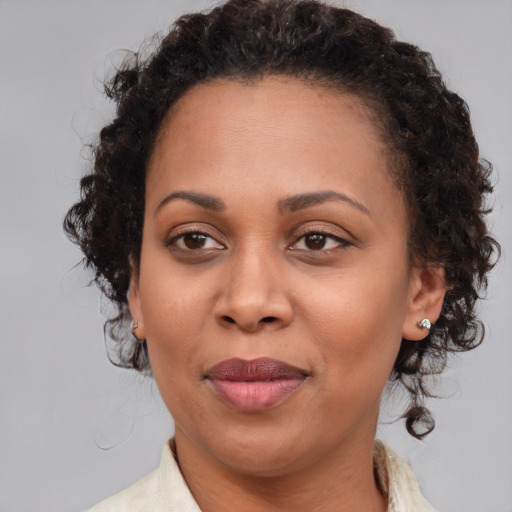 Joyful black adult female with medium  brown hair and brown eyes