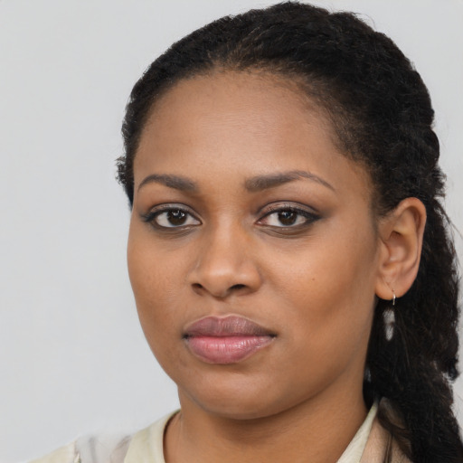 Joyful black young-adult female with long  black hair and brown eyes