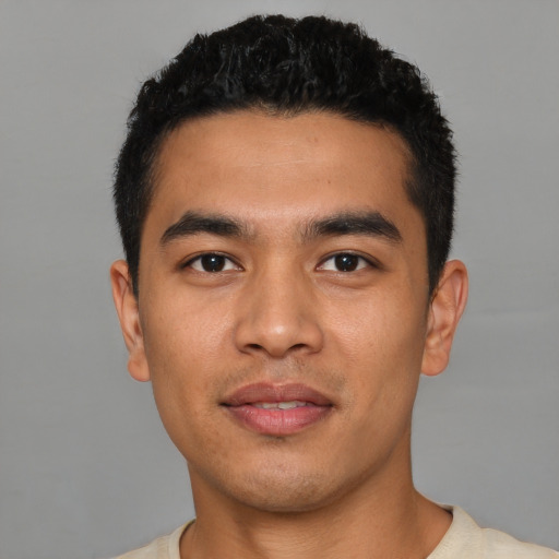 Joyful latino young-adult male with short  black hair and brown eyes
