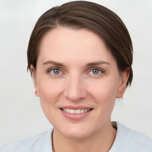 Joyful white young-adult female with short  brown hair and grey eyes