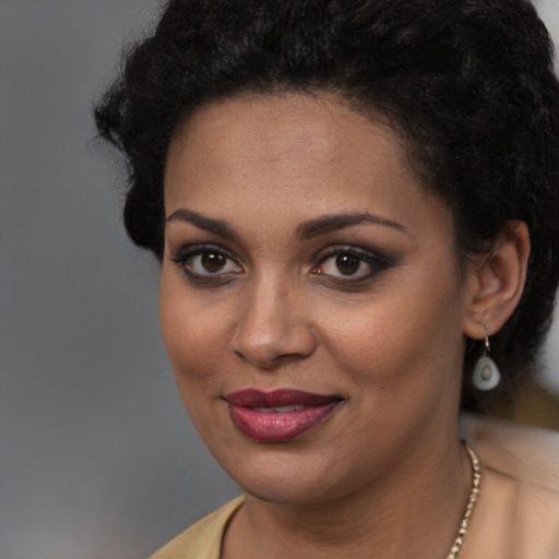 Joyful black young-adult female with long  brown hair and brown eyes