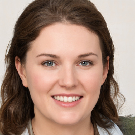 Joyful white young-adult female with medium  brown hair and grey eyes