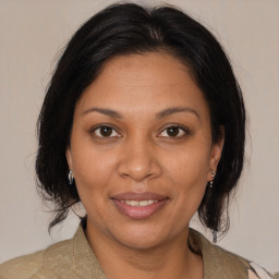 Joyful black adult female with medium  brown hair and brown eyes