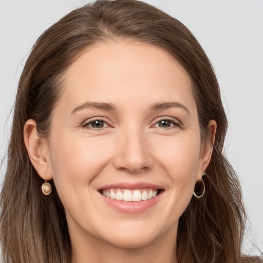 Joyful white young-adult female with long  brown hair and brown eyes