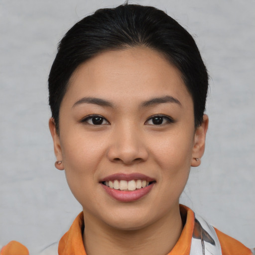 Joyful asian young-adult female with short  brown hair and brown eyes