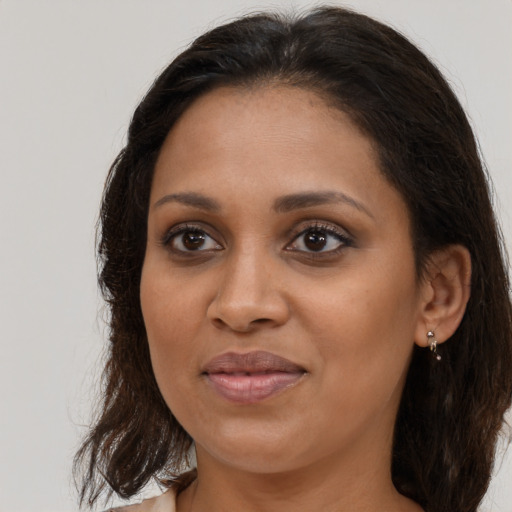 Joyful black young-adult female with long  brown hair and brown eyes