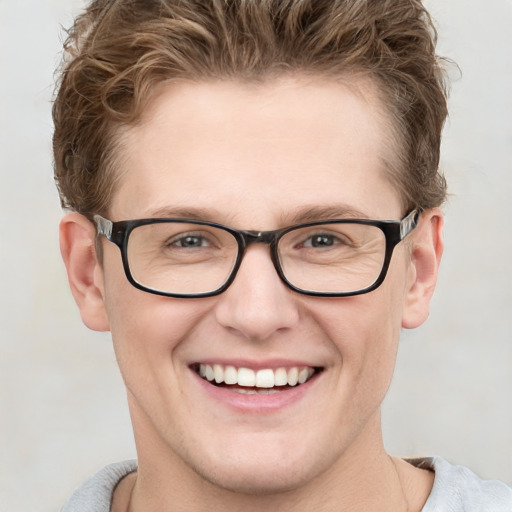 Joyful white young-adult male with short  brown hair and blue eyes