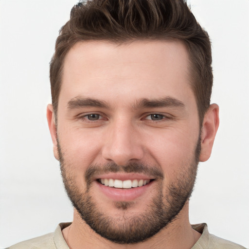 Joyful white young-adult male with short  brown hair and grey eyes