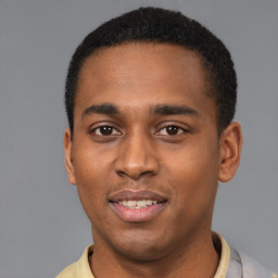 Joyful black young-adult male with short  brown hair and brown eyes