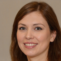 Joyful white young-adult female with long  brown hair and brown eyes