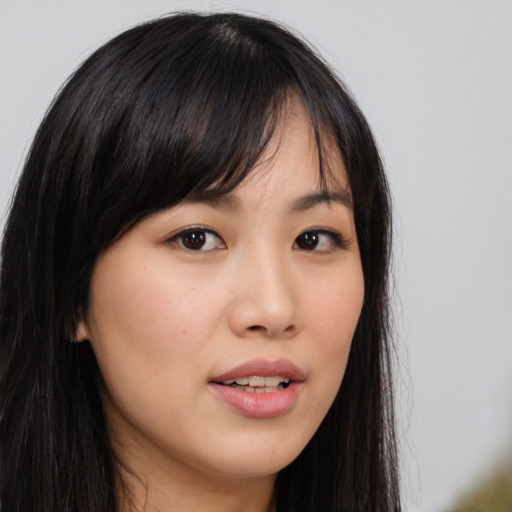 Joyful asian young-adult female with long  brown hair and brown eyes