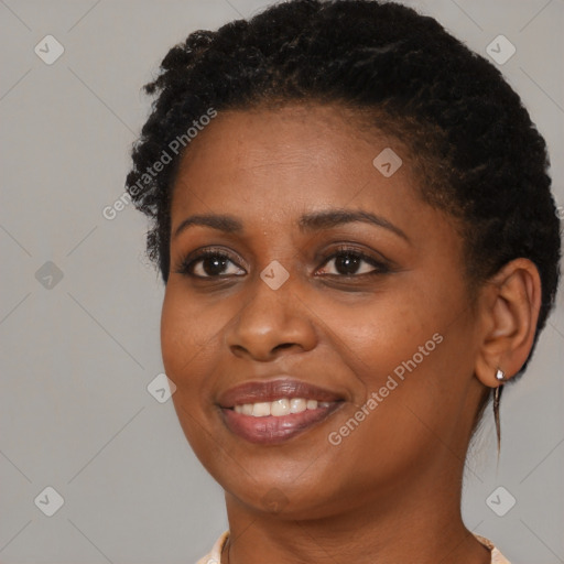 Joyful black young-adult female with short  black hair and brown eyes