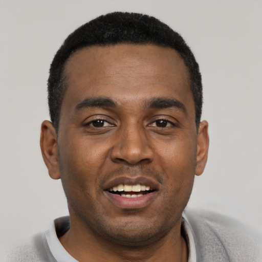 Joyful black young-adult male with short  black hair and brown eyes