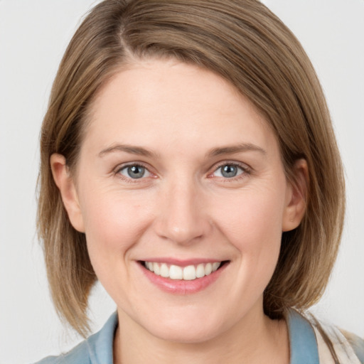 Joyful white young-adult female with medium  brown hair and blue eyes