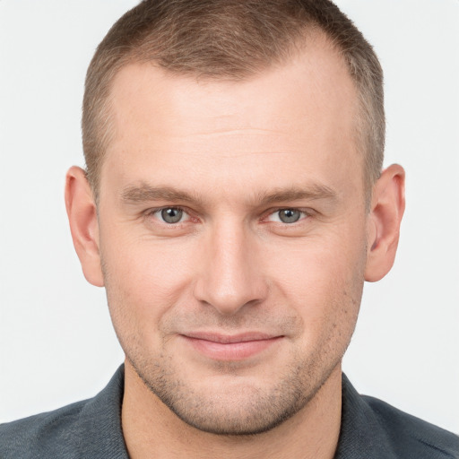 Joyful white young-adult male with short  brown hair and grey eyes