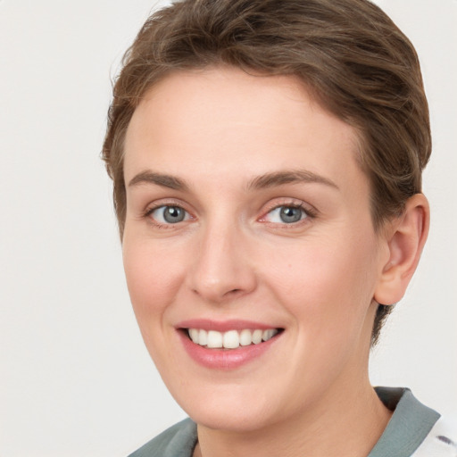 Joyful white young-adult female with short  brown hair and grey eyes