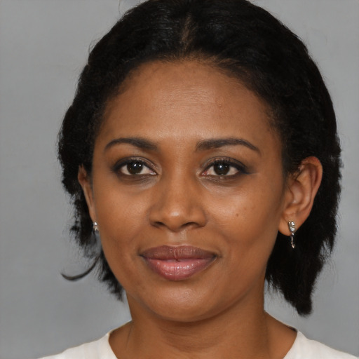 Joyful black adult female with medium  black hair and brown eyes