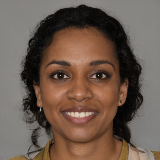 Joyful black young-adult female with medium  black hair and brown eyes