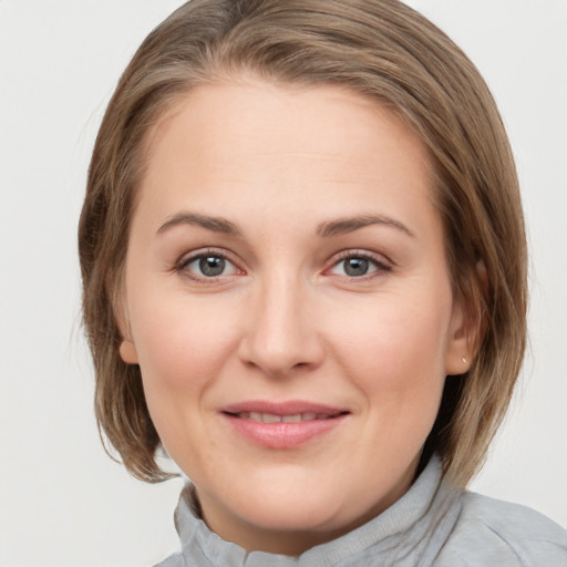 Joyful white young-adult female with medium  brown hair and grey eyes