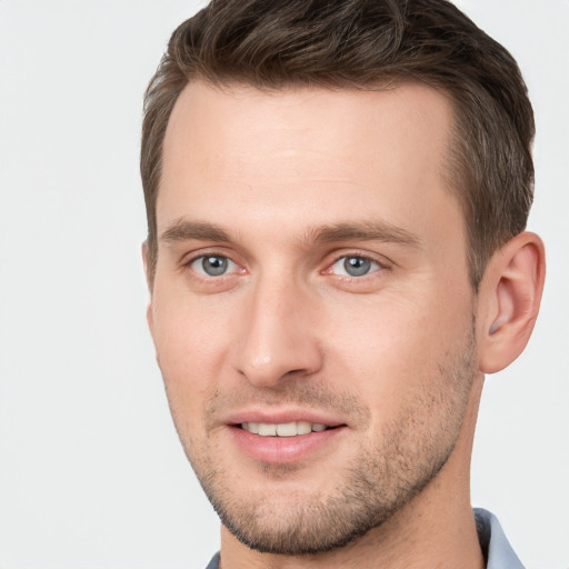 Joyful white young-adult male with short  brown hair and grey eyes