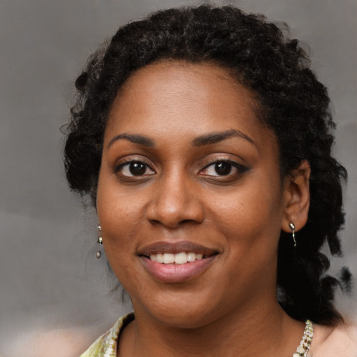 Joyful black young-adult female with short  brown hair and brown eyes