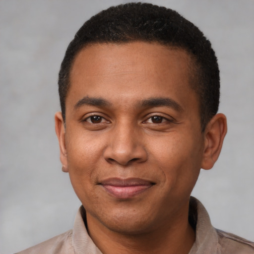 Joyful latino young-adult male with short  black hair and brown eyes