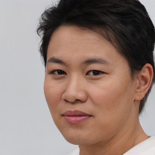 Joyful asian young-adult female with short  brown hair and brown eyes