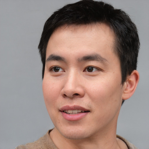 Joyful asian young-adult male with short  brown hair and brown eyes