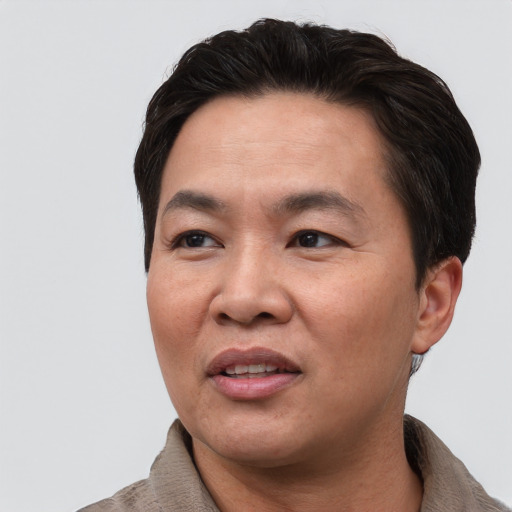 Joyful asian adult male with short  black hair and brown eyes