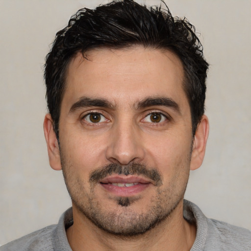 Joyful white young-adult male with short  black hair and brown eyes