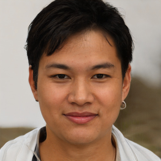 Joyful asian young-adult male with short  brown hair and brown eyes