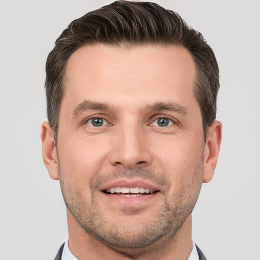 Joyful white adult male with short  brown hair and brown eyes